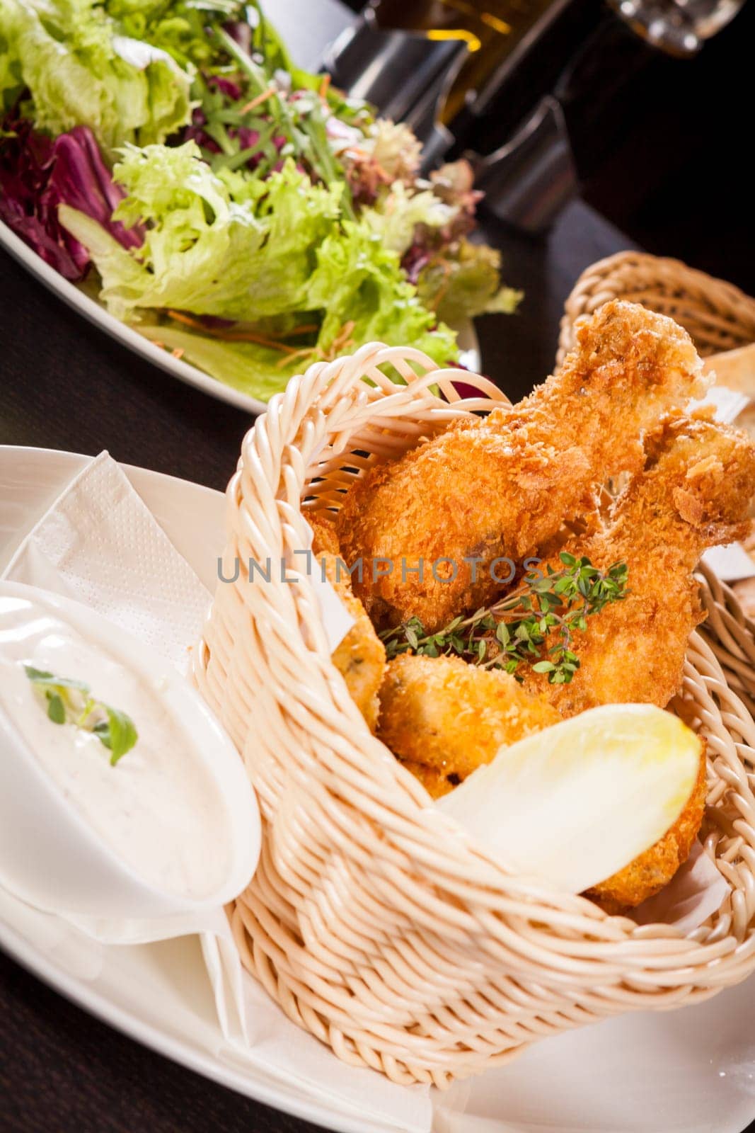 Crispy fried chicken wings with a dip on a plate