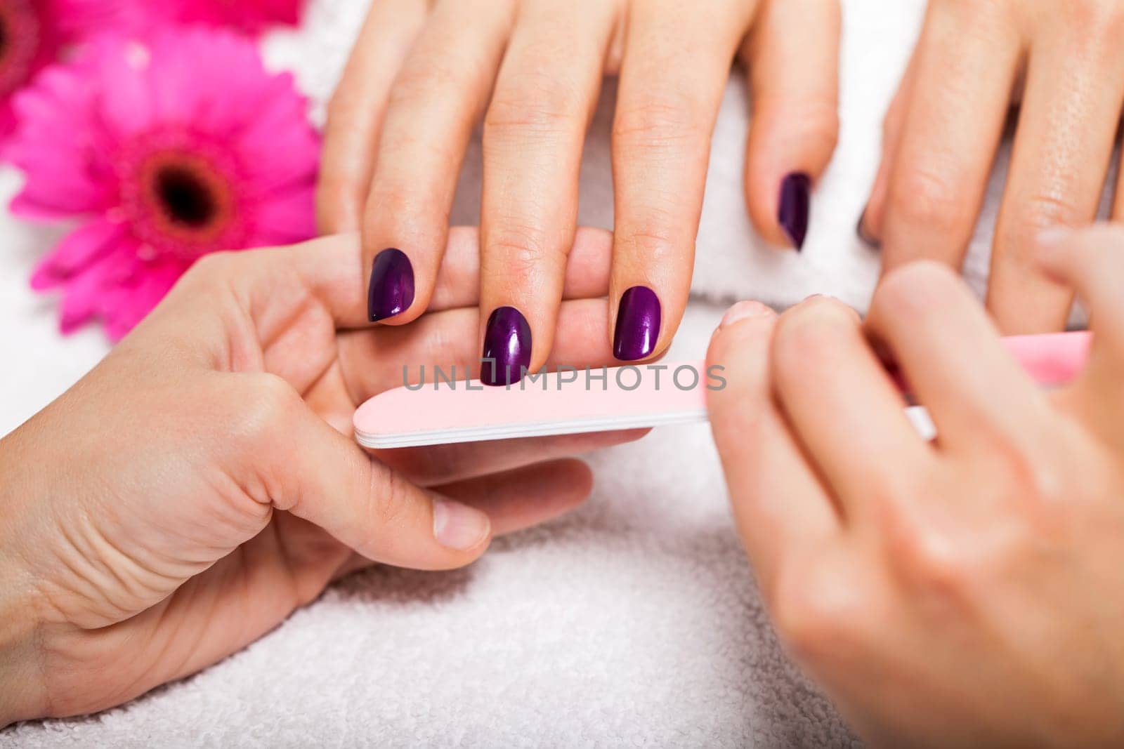 Professional nail designer at a manicure with female hands in a nail salon