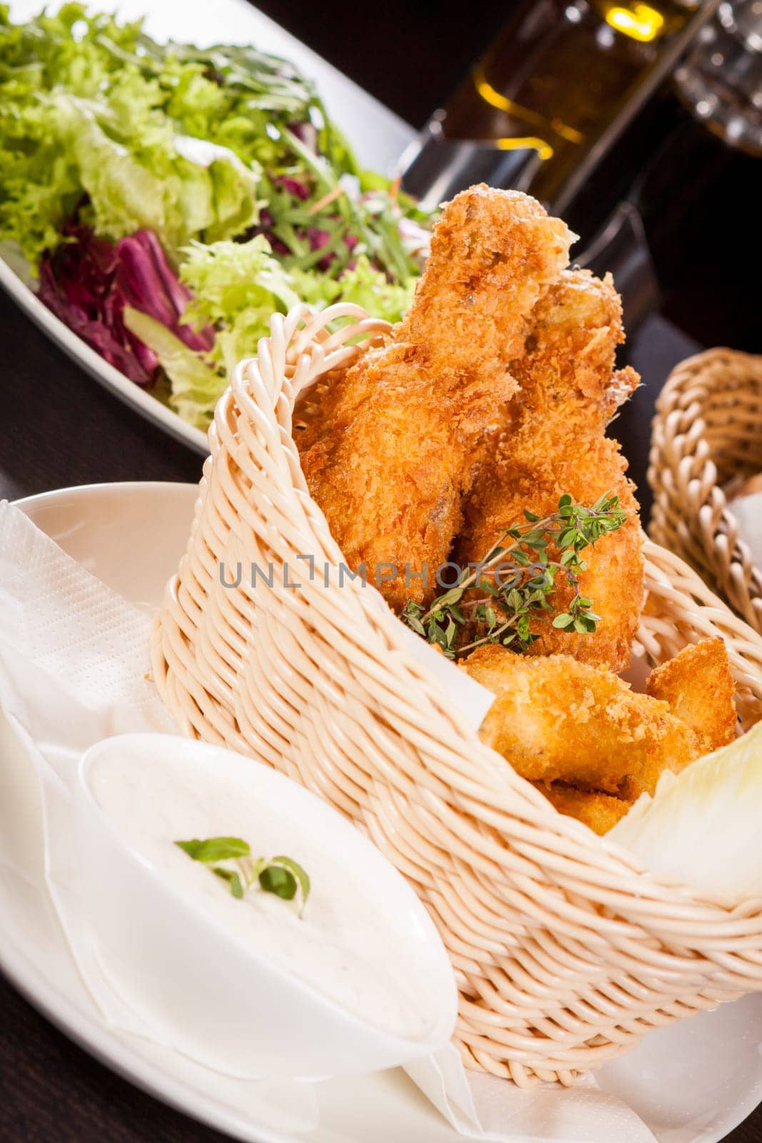 Crispy fried chicken wings with a dip on a plate