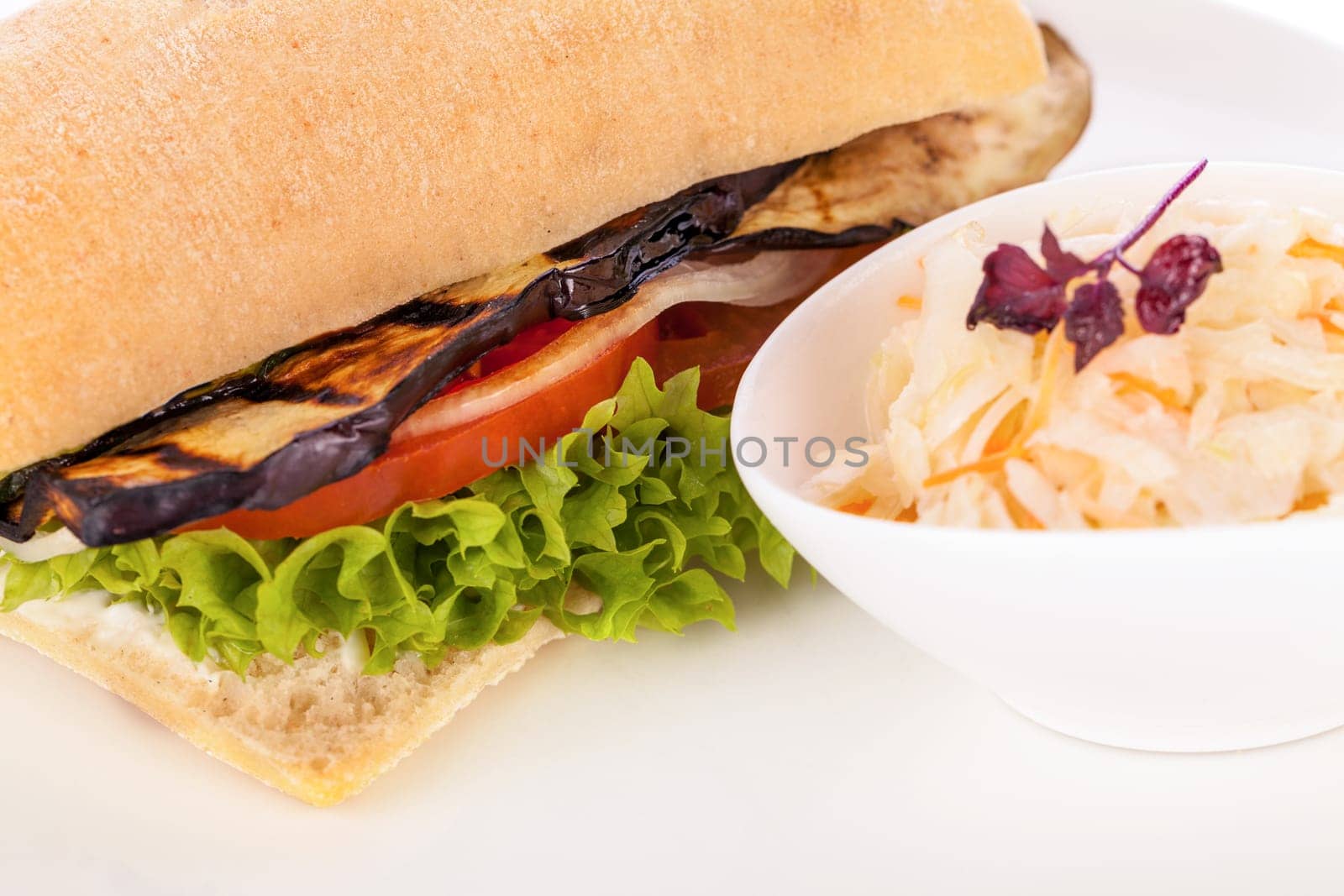 Vegetarian vegan hamburger with aubergine tomato and salad in a ciabatta bun isolated on a white background