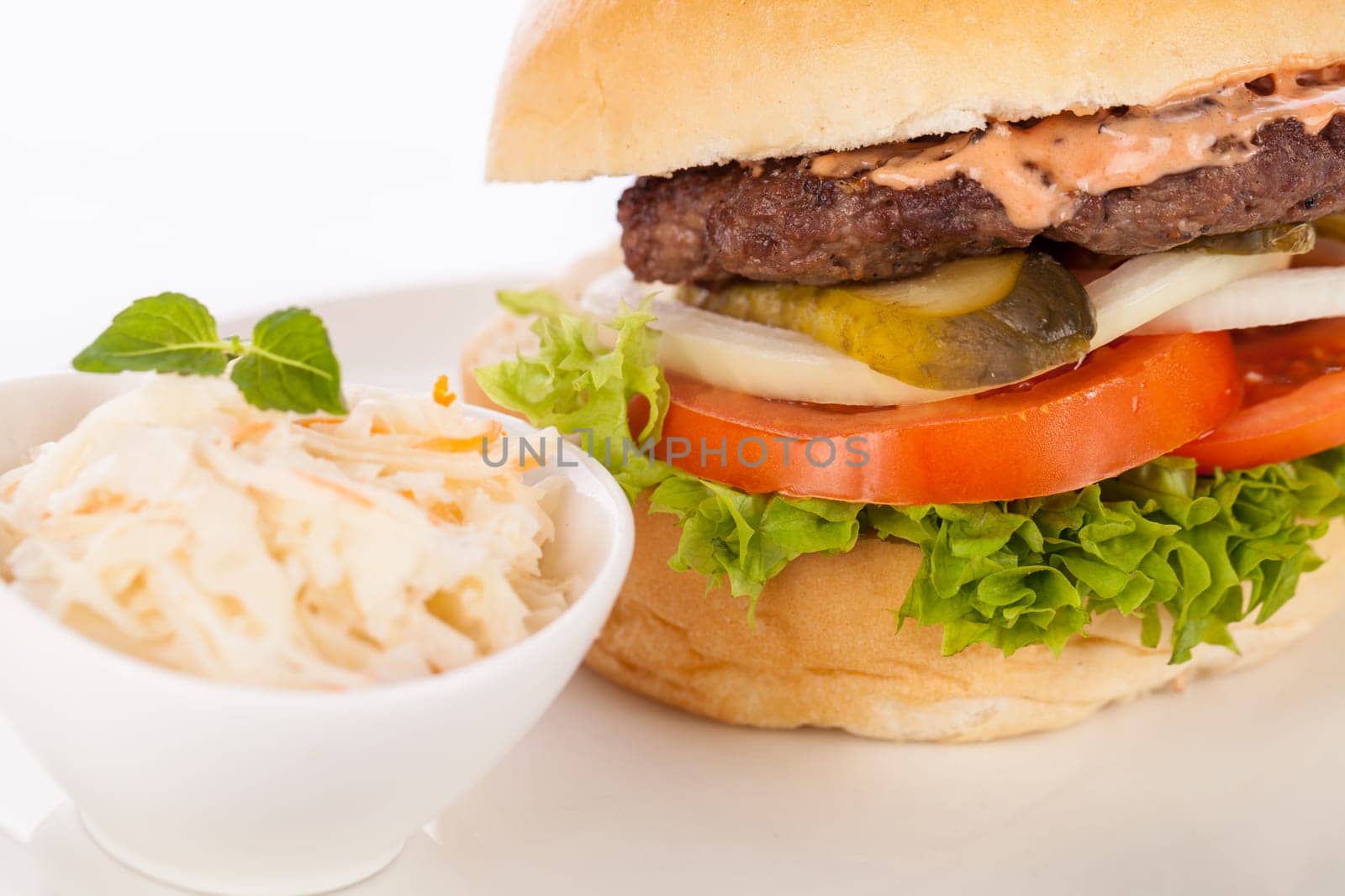 Delicious hamburger cheeseburger with bacon egg and salad on a plate isolated on a white background