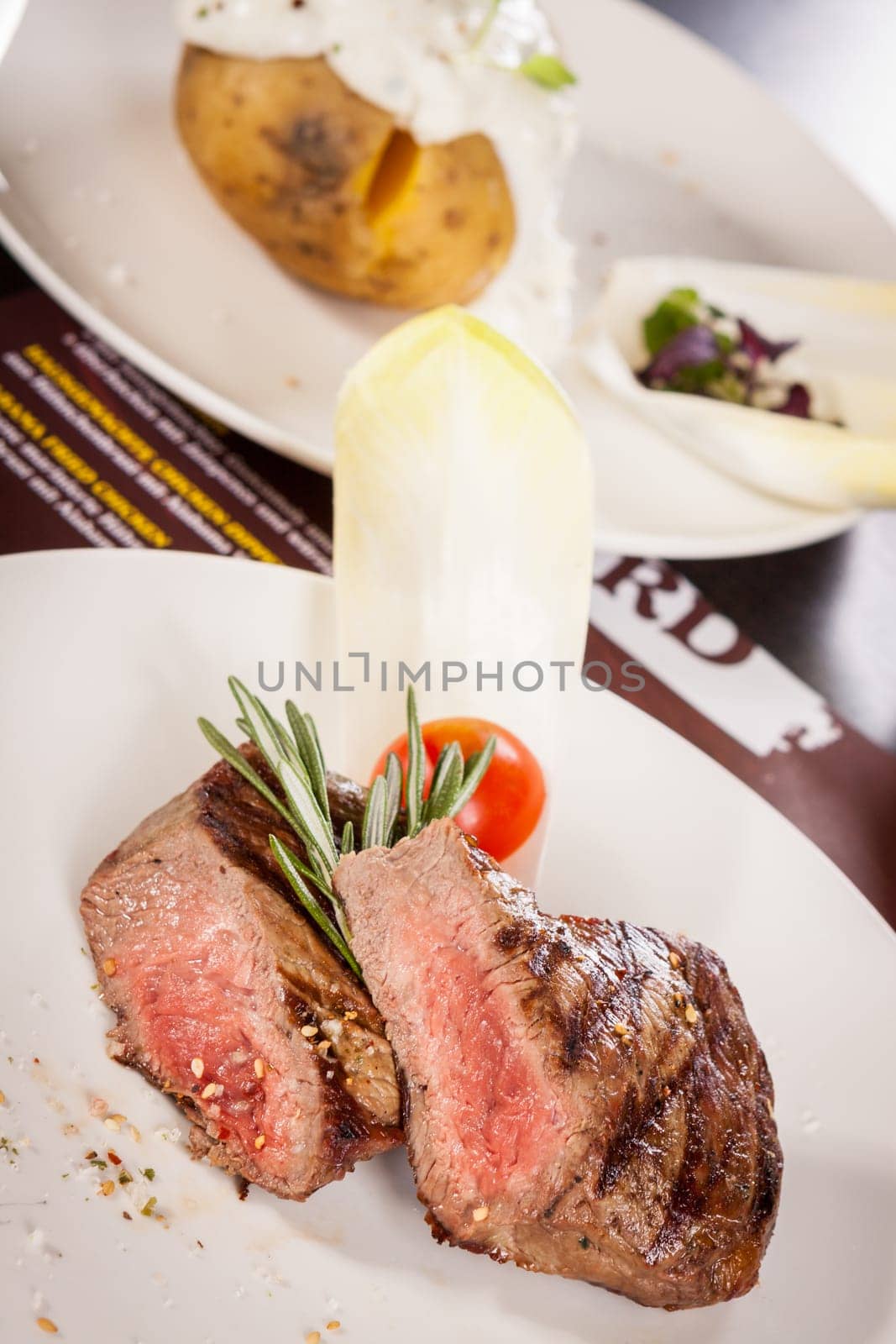 Medium fried beef steak fillet with pepper and rosemary sliced on a plate