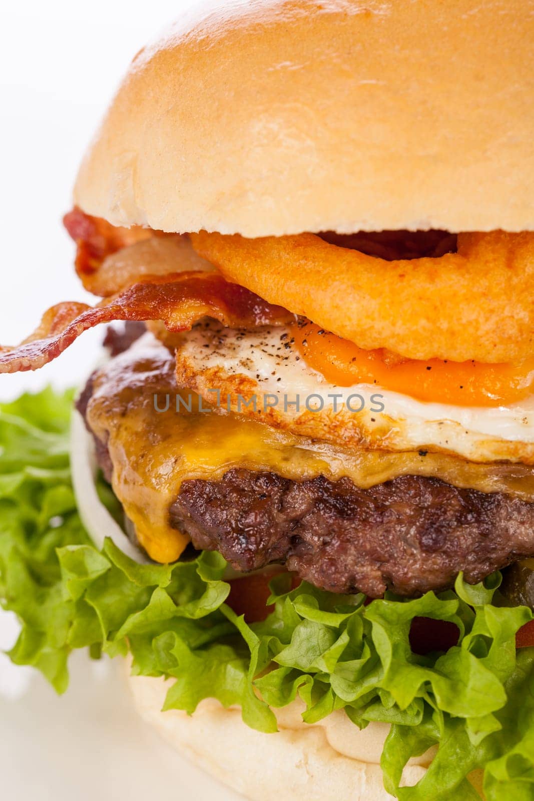 Delicious hamburger cheeseburger with bacon egg and salad on a plate isolated on a white background