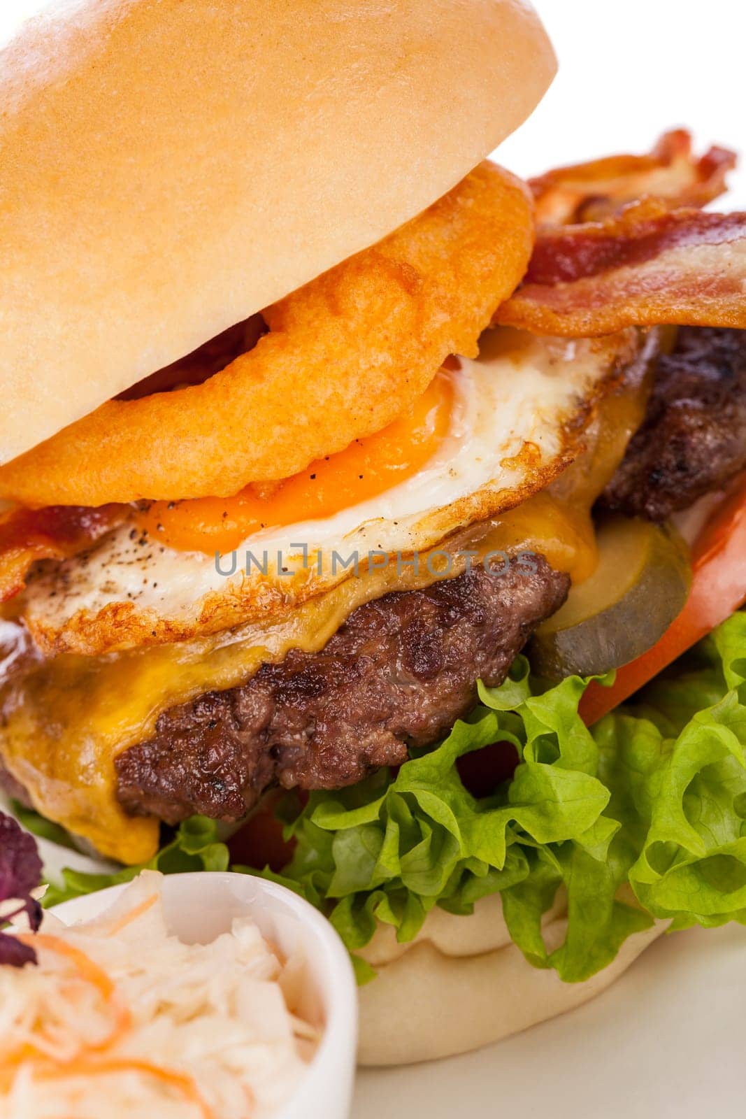 Delicious hamburger cheeseburger with bacon egg and salad on a plate isolated on a white background