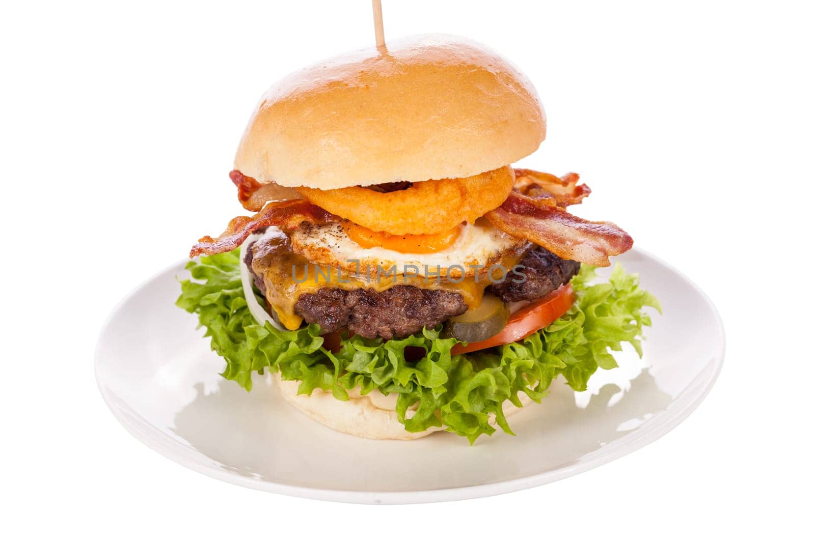 Delicious hamburger cheeseburger with bacon egg and salad on a plate isolated on a white background