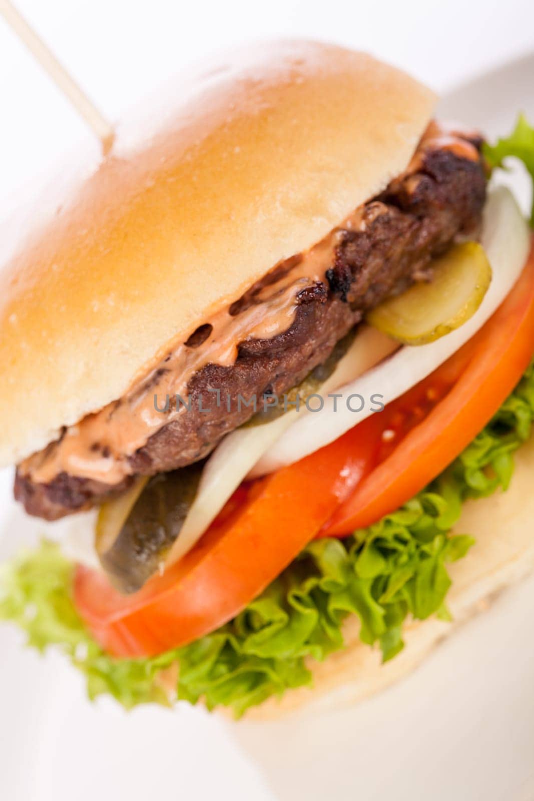 Delicious hamburger cheeseburger with bacon egg and salad on a plate isolated on a white background