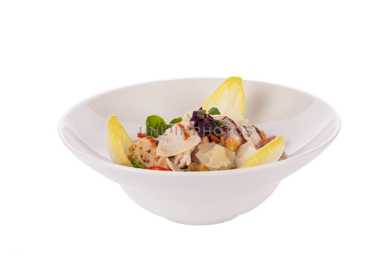 Fresh delicious caesarsalat with grilled chicken bust parmesan shards and croutons isolated against a white background