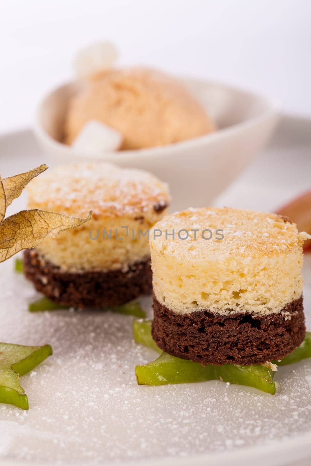 Brownie chocolate brownie with ice cream and plums prepared on a plate insulated against a white background