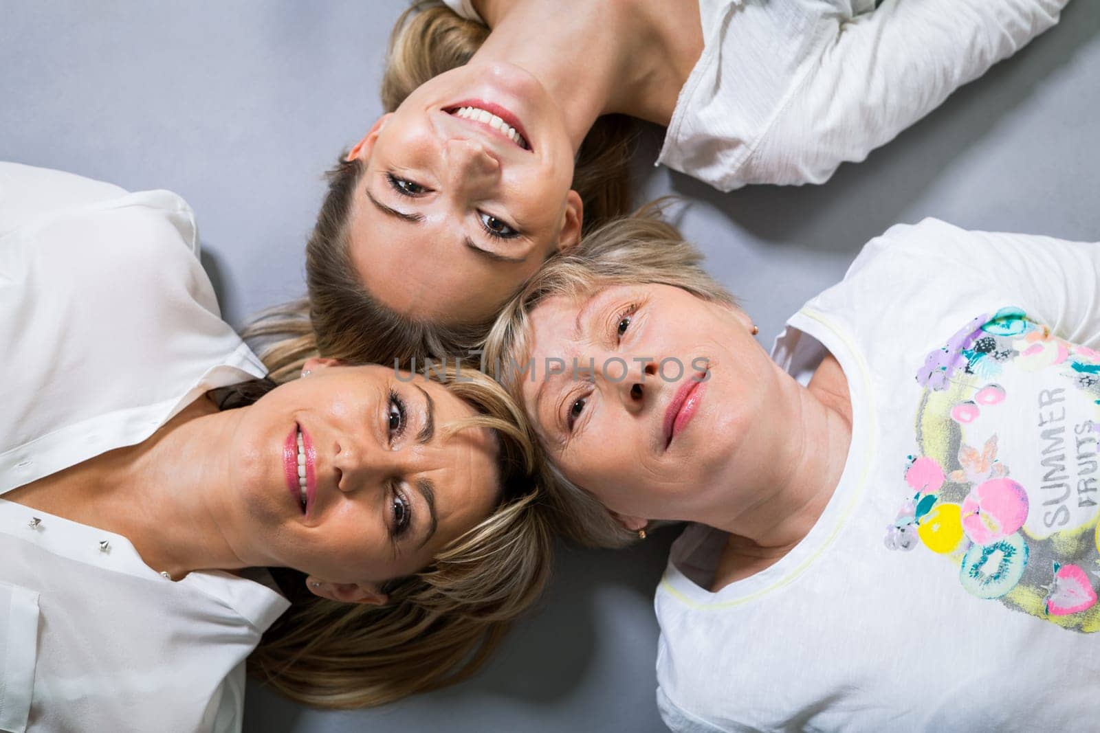 three generations grandmother mother and daughter in portrait against grey background family