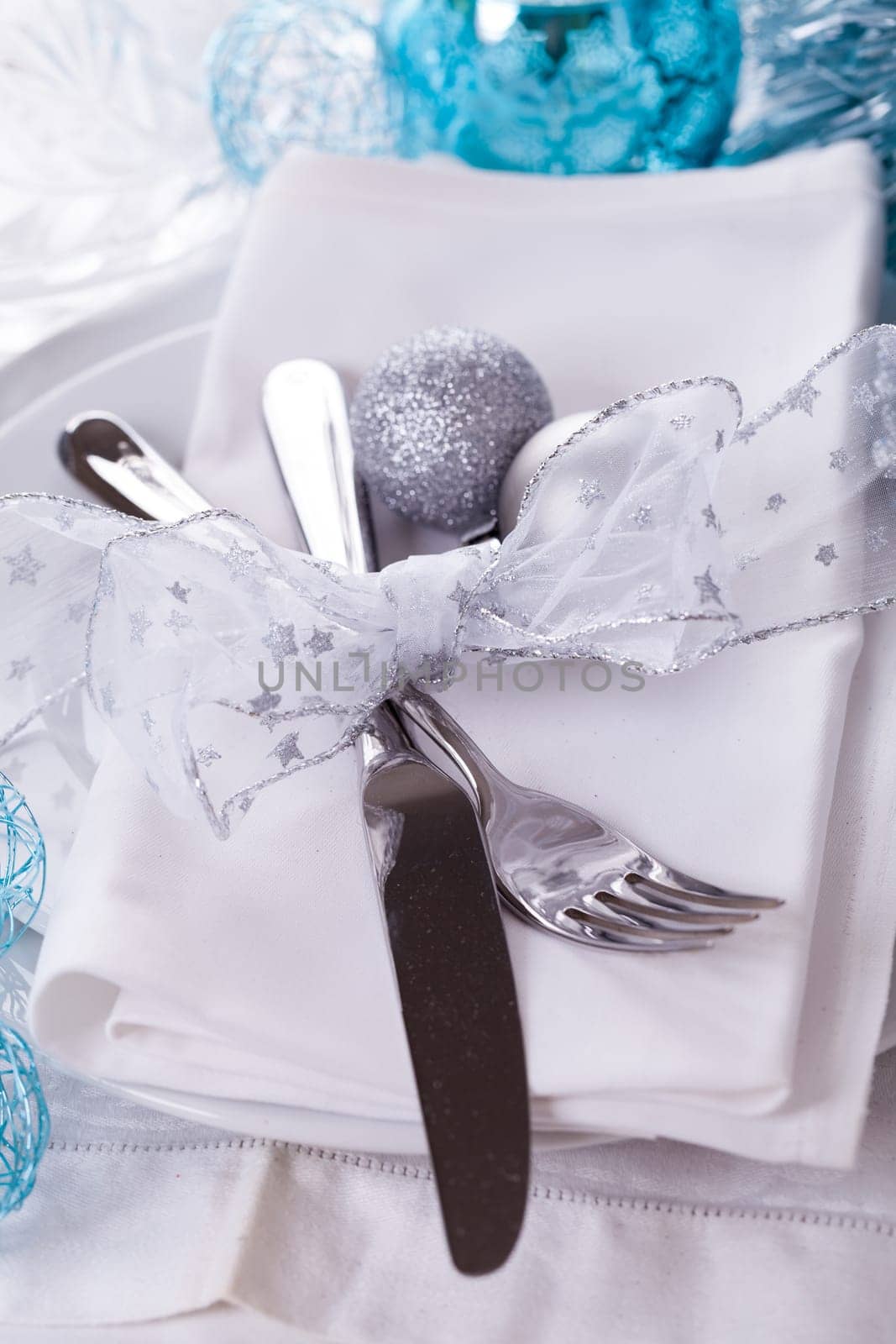 Stylish table with Christmas decoration in turquoise and silver shiny with cutlery