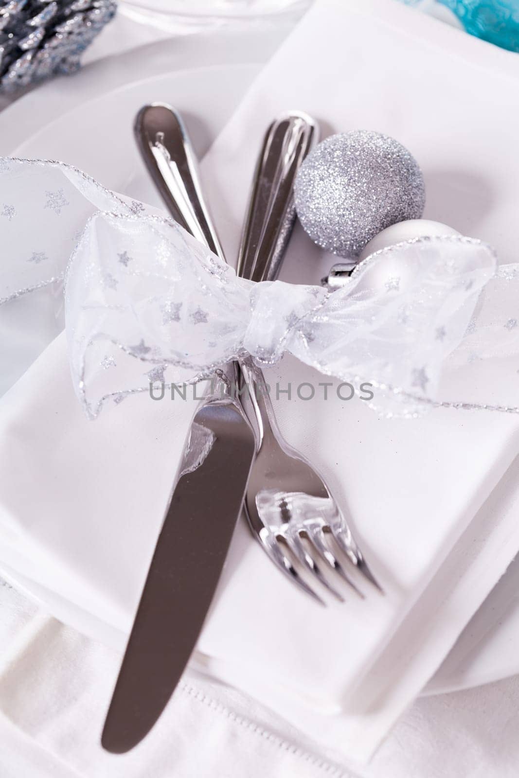 Stylish table with Christmas decoration in turquoise and silver shiny with cutlery