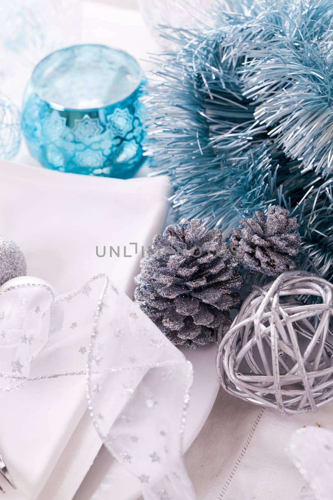 Stylish table with Christmas decoration in turquoise and silver shiny with cutlery