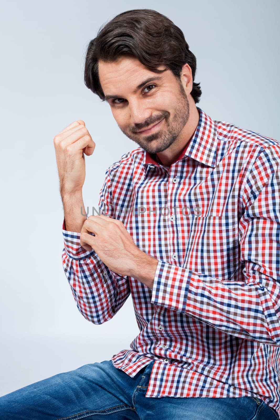 Young man with beard and dark hair with jeans and carated shirt