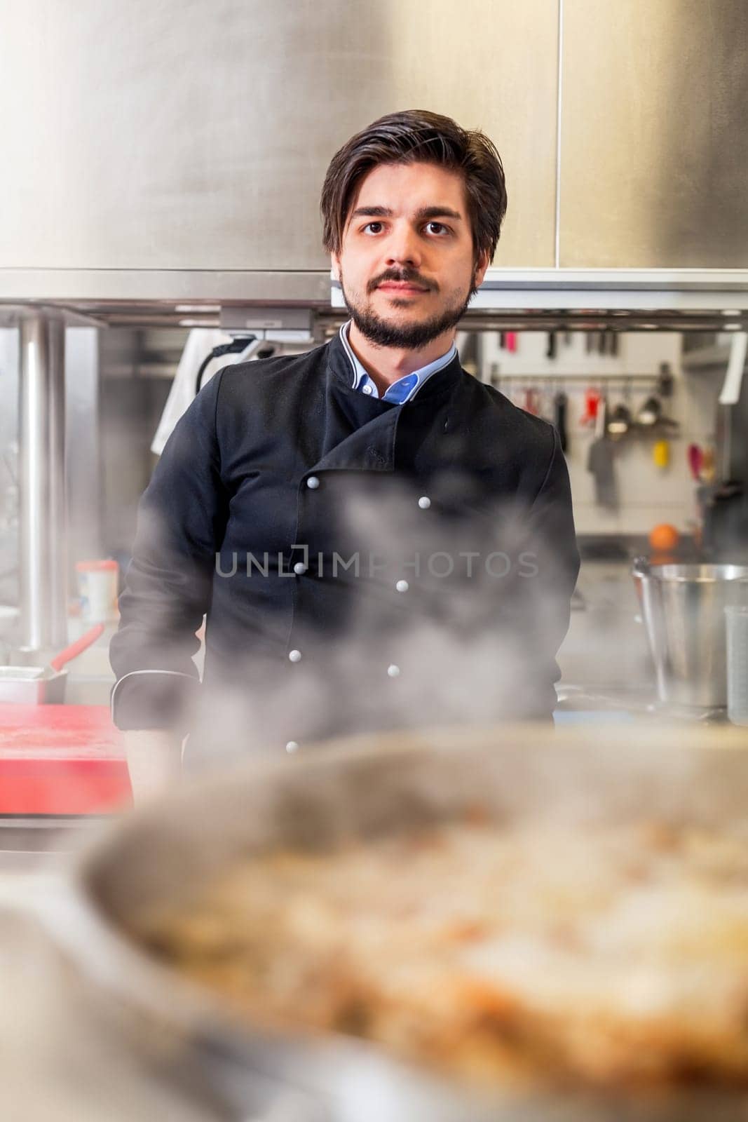 young adult chef in the restaurant kitchen while cooking at the herd preparation