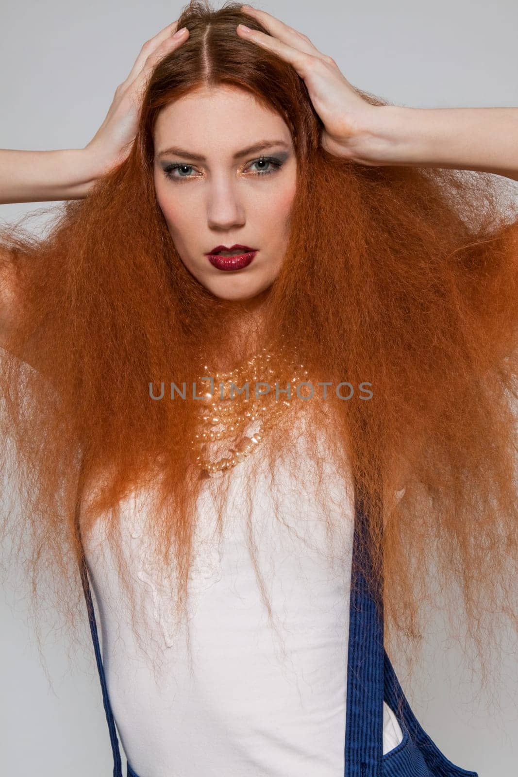 Young attractive pretty woman with long red hair and ripped hairstyle in portrait