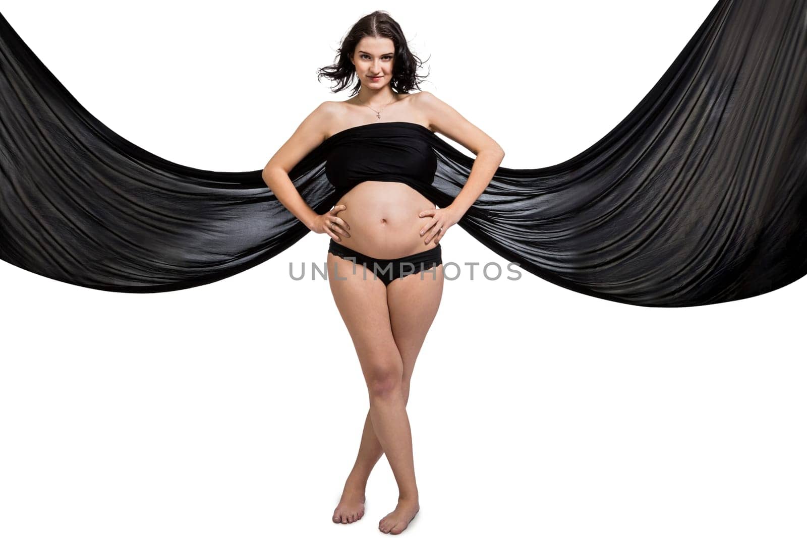 Young attractive pregnant woman wrapped in black fabric insulated against white background