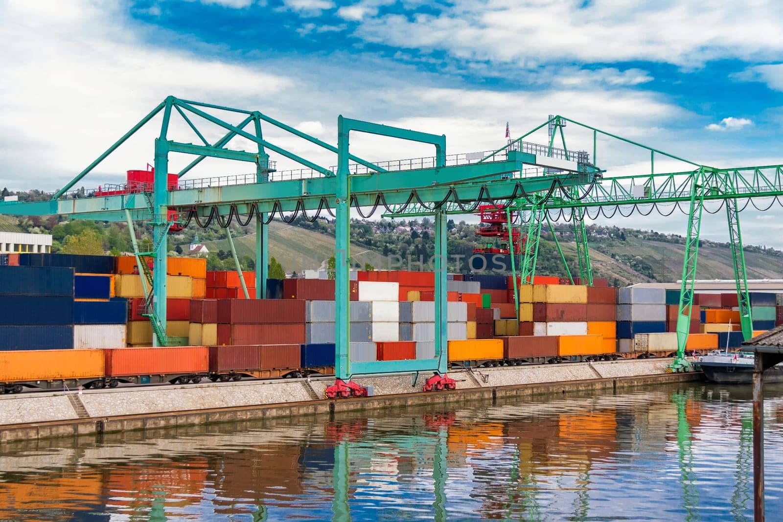 Dock in the port with stacked containers at the dock for import and export cargo with blue sky