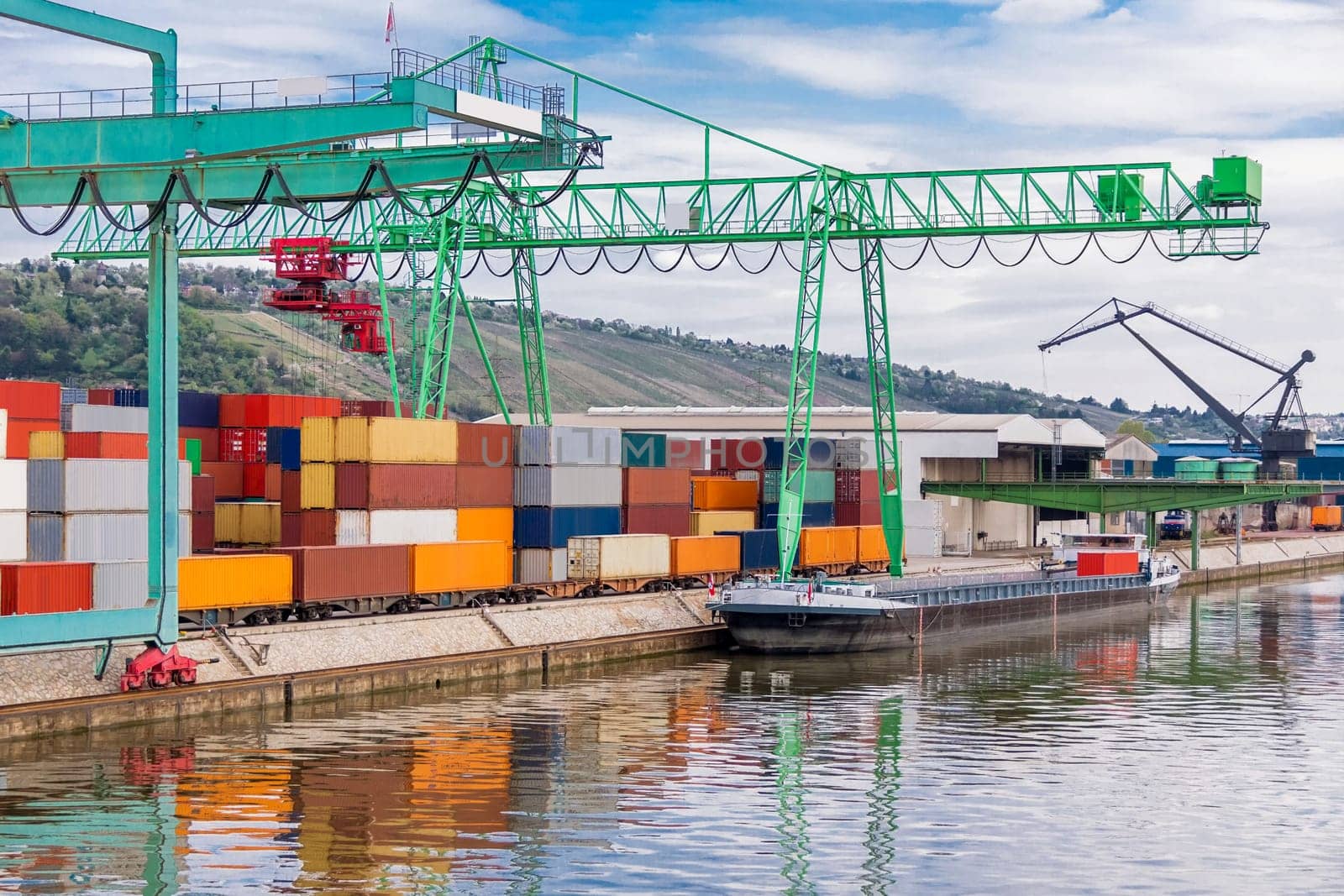 Dock in the port with stacked containers at the dock for import and export cargo with blue sky