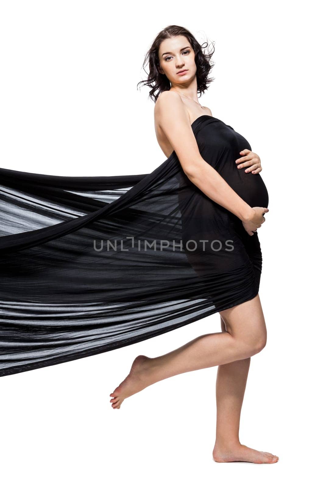 Young attractive pregnant woman wrapped in black fabric insulated against white background
