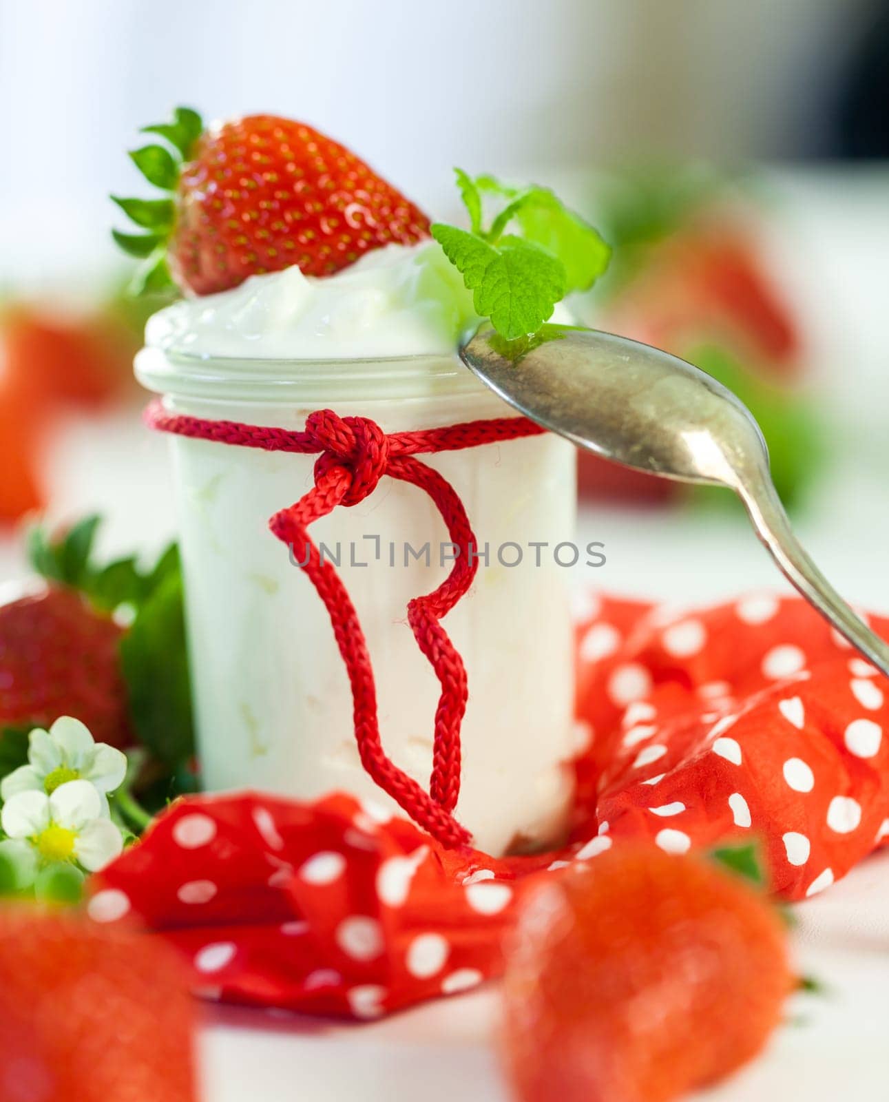 Fresh yoghurt with strawberries in a glass insulated on a white background