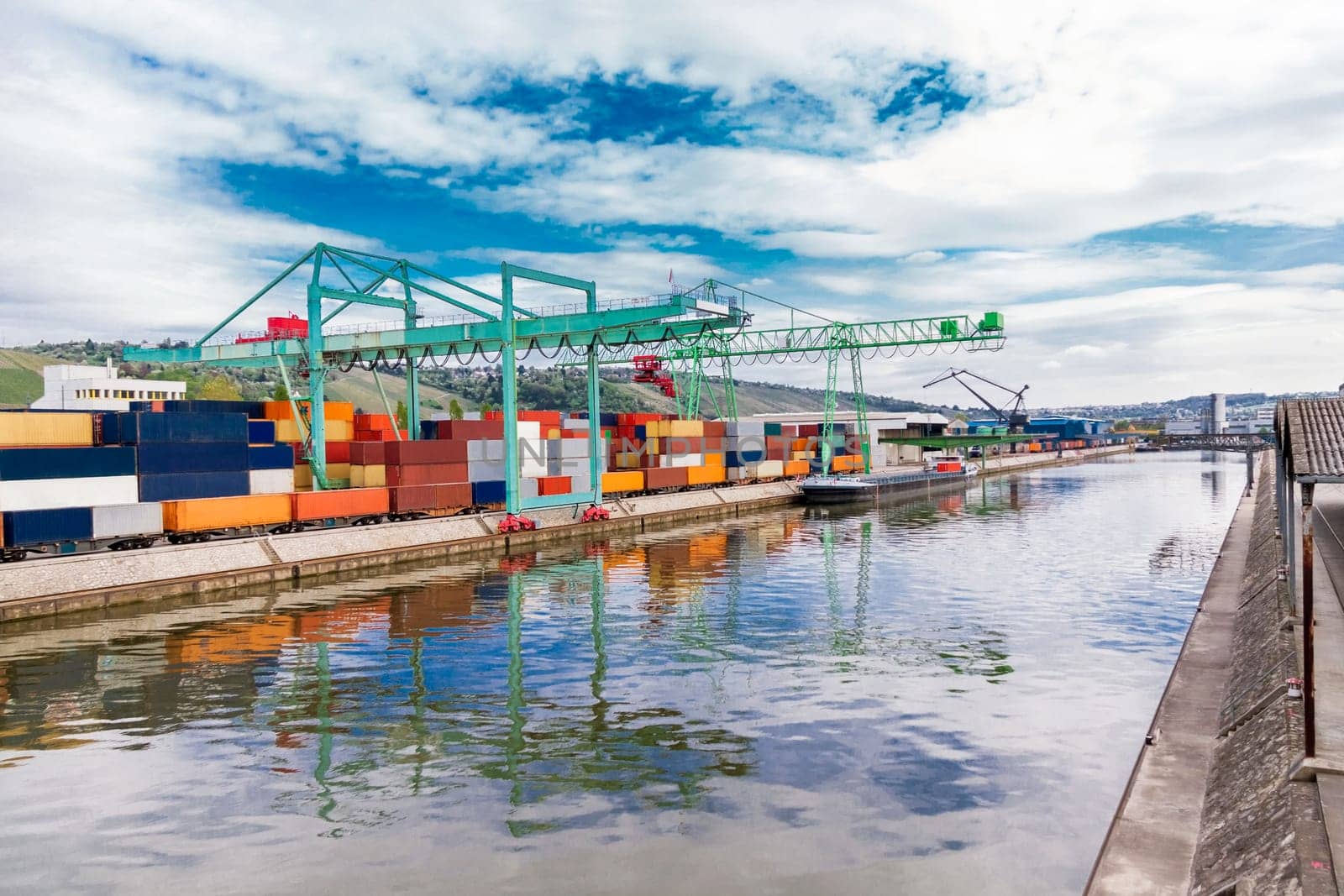 Dock in the port with stacked containers at the dock for import and export cargo with blue sky