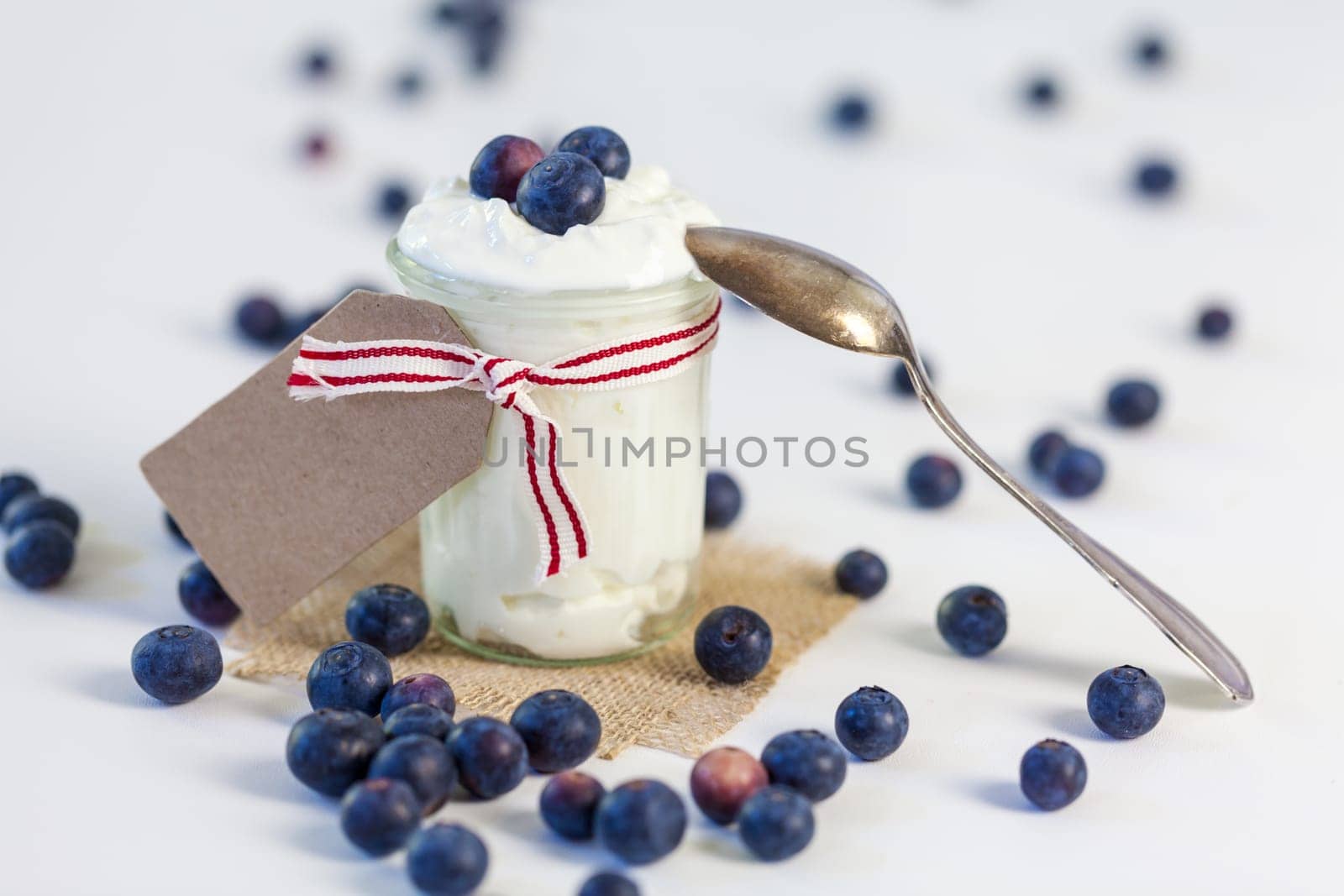 Glass with yoghurt and fresh blueberries blueberries for breakfast and for dessert