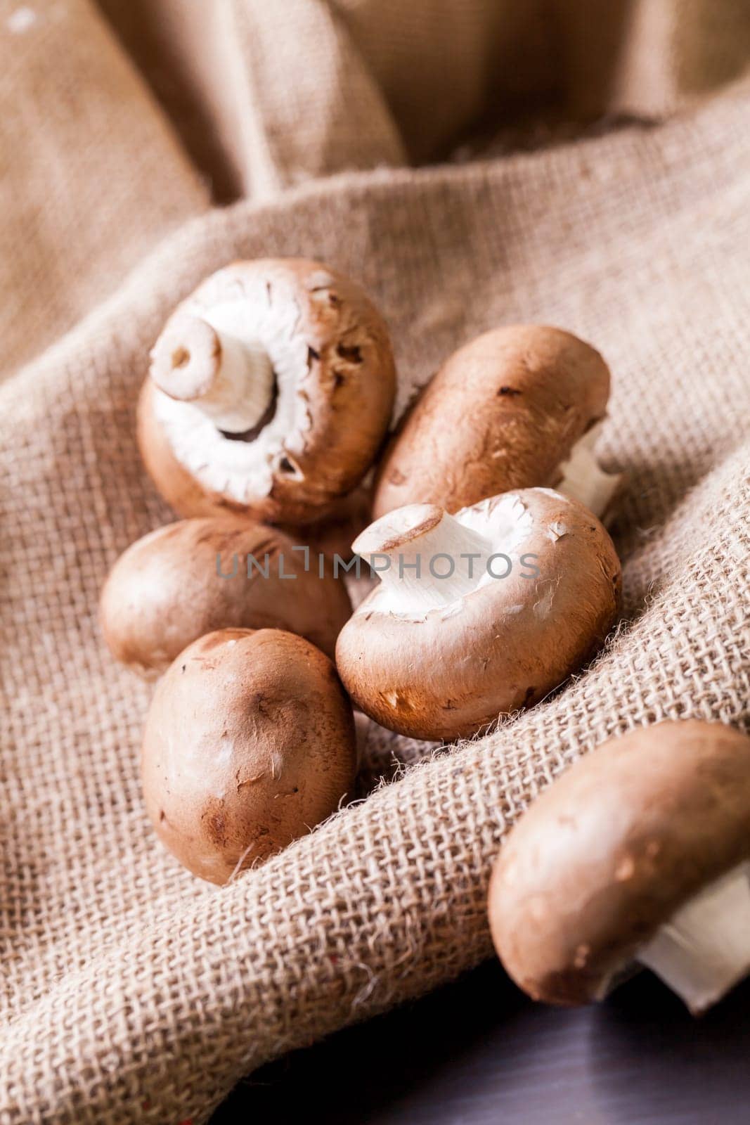 Fresh braund champignons in sunlight on a wooden table in daylight