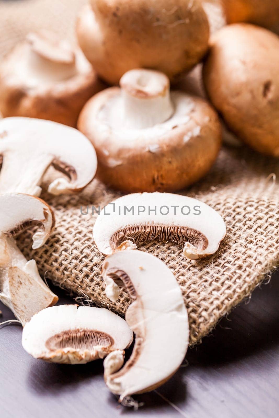 Fresh braund champignons in sunlight on a wooden table in daylight