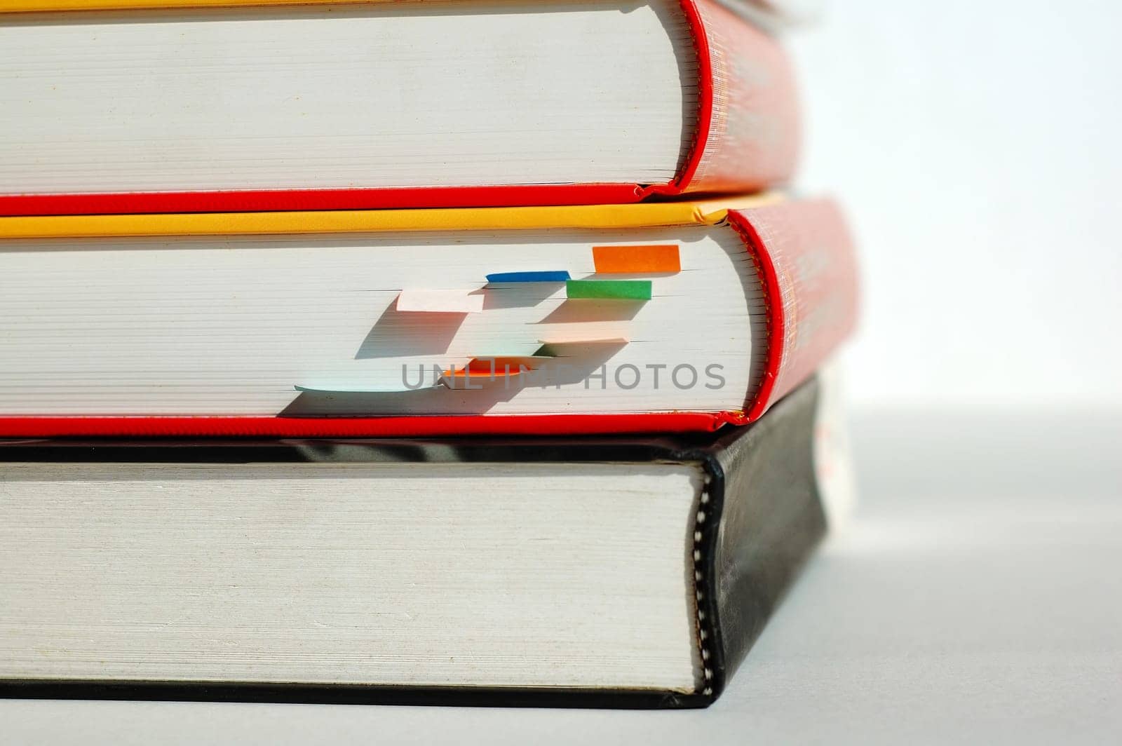 Three books are piled together, and the middle one is with markers