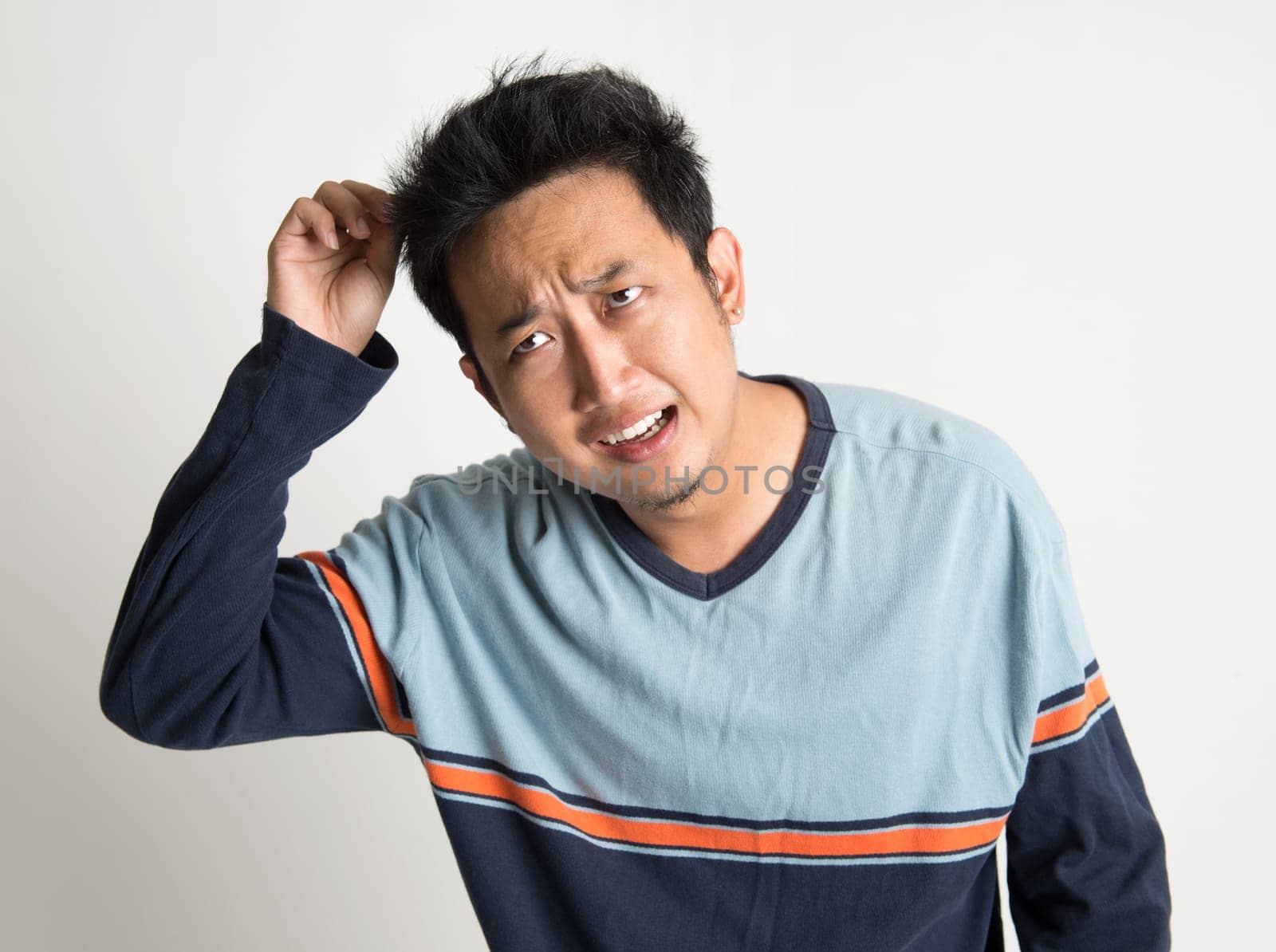 Asian man with bad hairstyle, on plain background