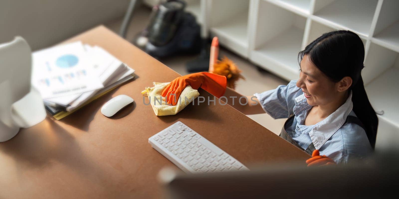 Asian woman cleaning in work room at home. Young woman housekeeper cleaner use a cloth to wipe equipment for working. concept housekeeping housework cleaning.