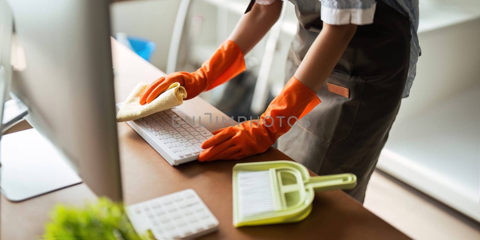 Asian woman cleaning in work room at home. Young woman housekeeper cleaner use a cloth to wipe equipment for working. concept housekeeping housework cleaning by nateemee