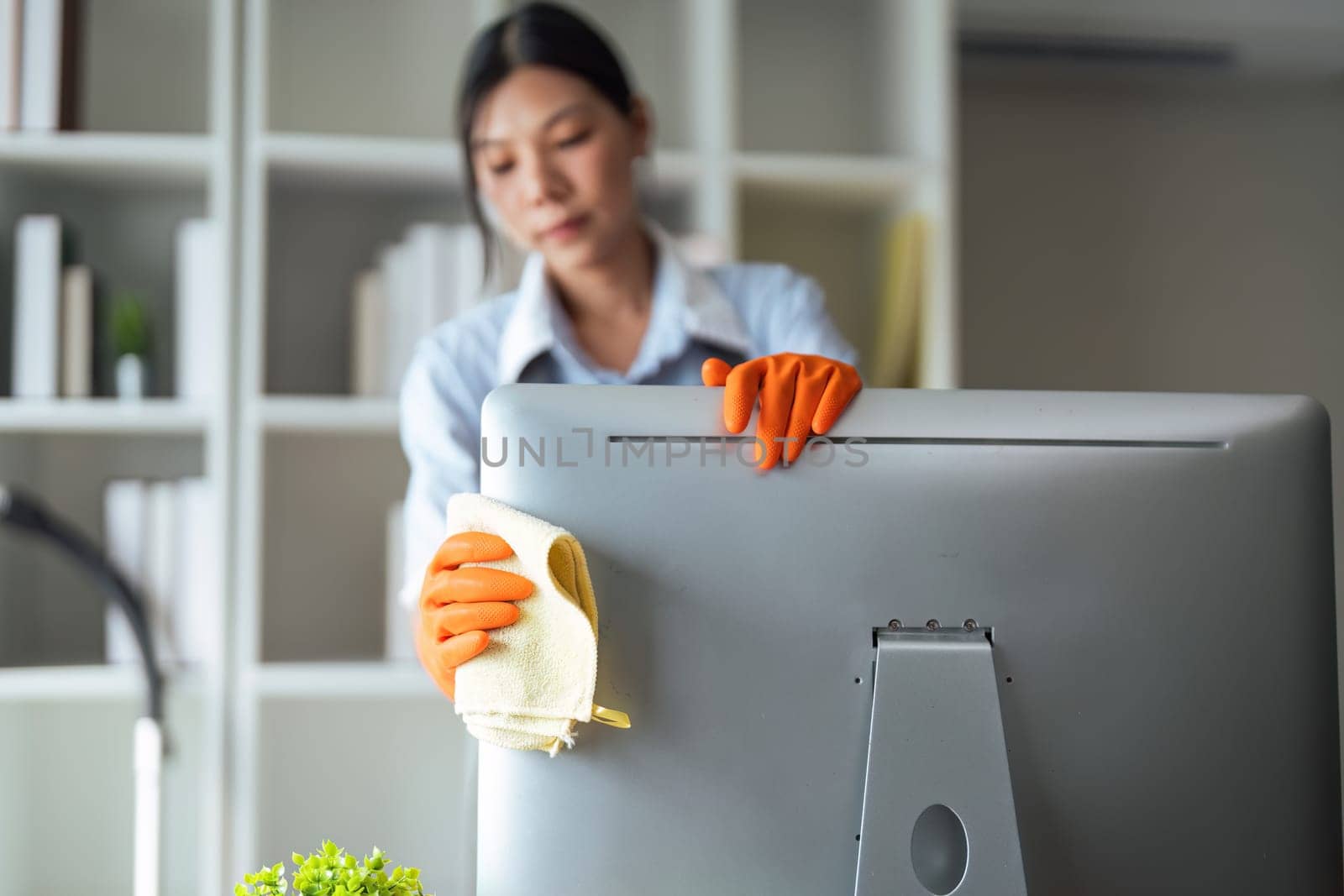 Asian woman cleaning in work room at home. Young woman housekeeper cleaner use a cloth to wipe equipment for working. concept housekeeping housework cleaning.