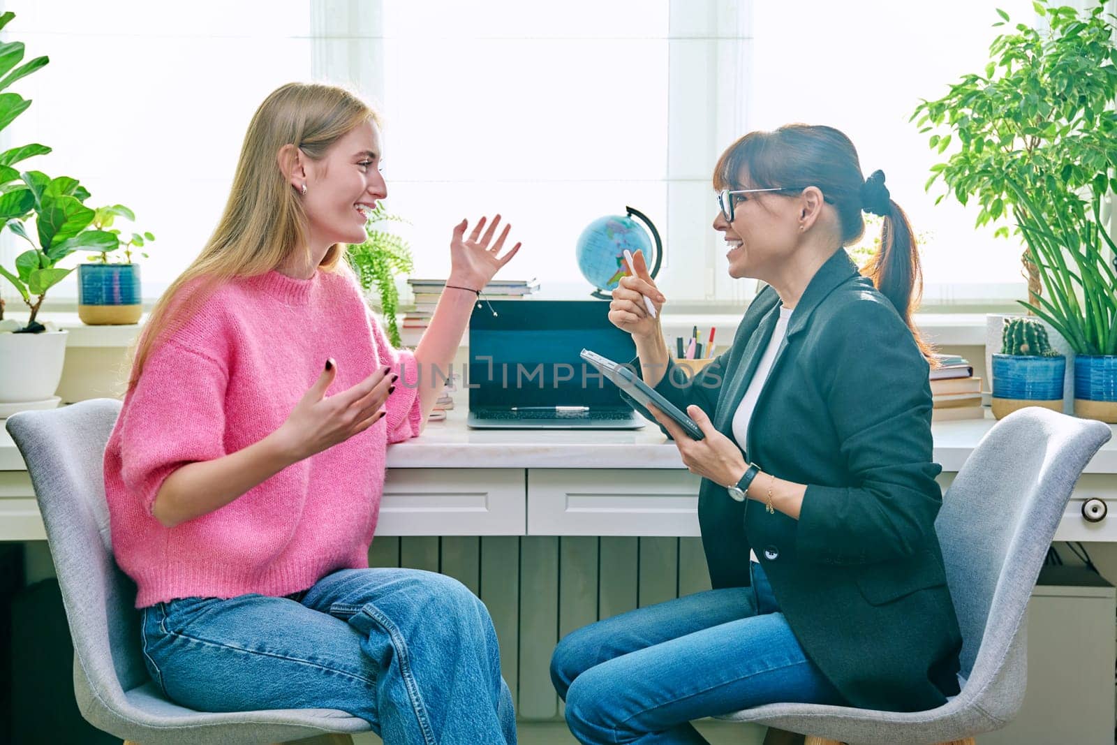 Young female at therapy meeting with psychotherapist. Session of teenage student girl, psychologist with digital tablet talking to patient. Psychology, psychotherapy, treatment, youth mental health