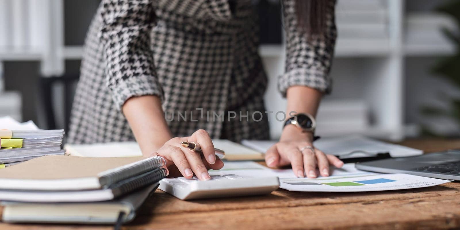 Close up, Business woman using calculator for do math finance on wooden desk in office and business working background, tax, accounting, statistics and analytic research concept..