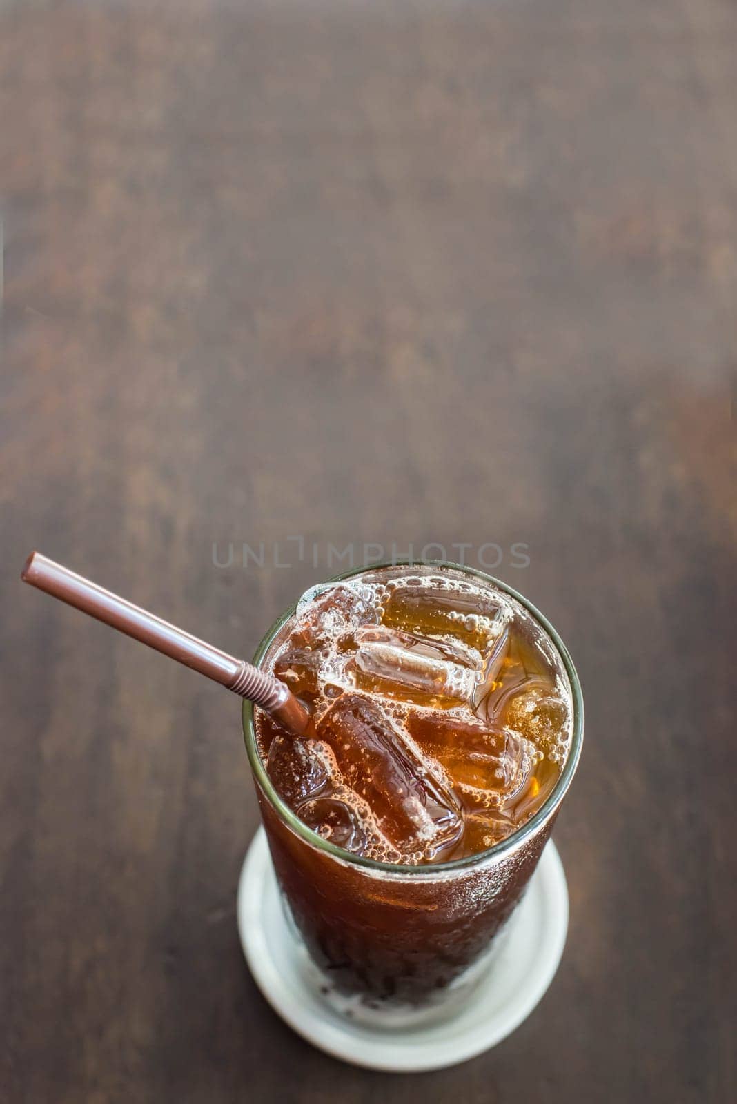 Iced black coffee on the wooden table in coffee cafe.