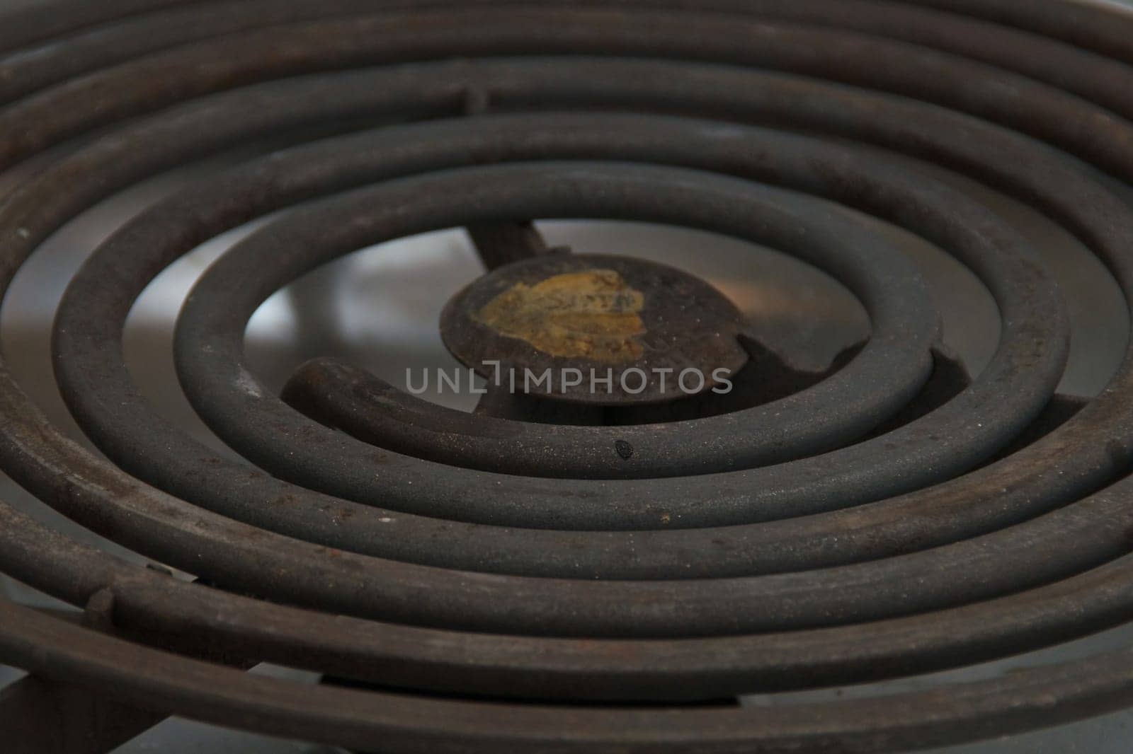 A coiled electric heating element on a modern stove up close.