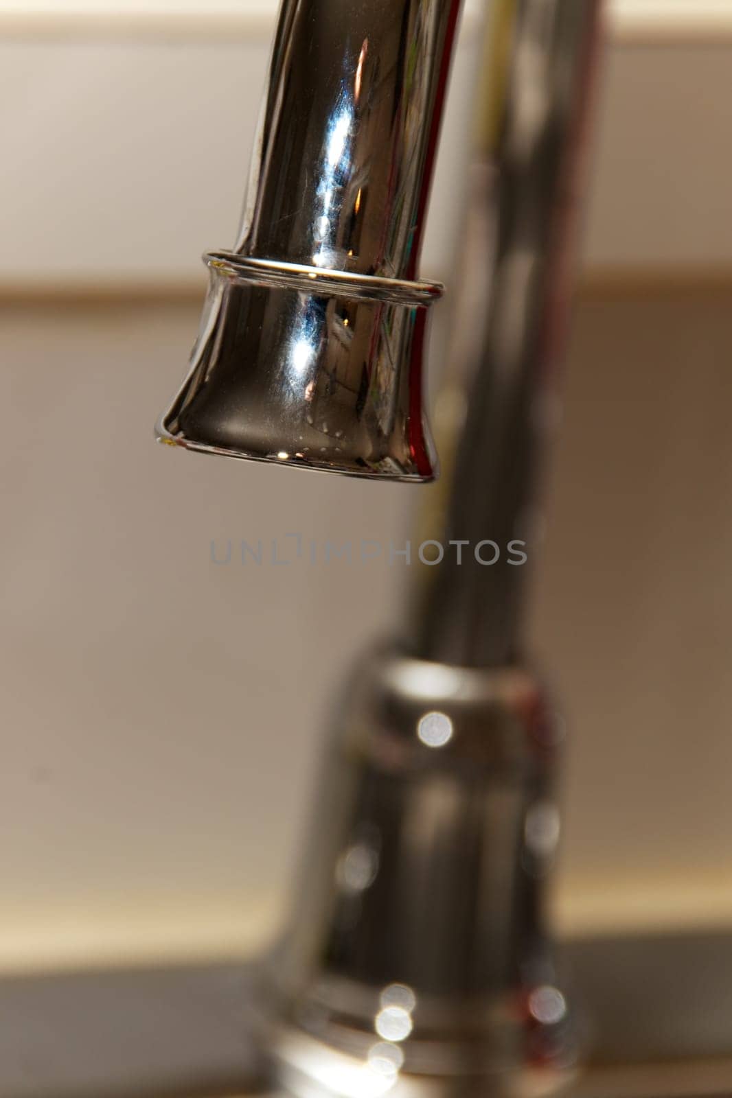A chrome kitchen water faucet up close.