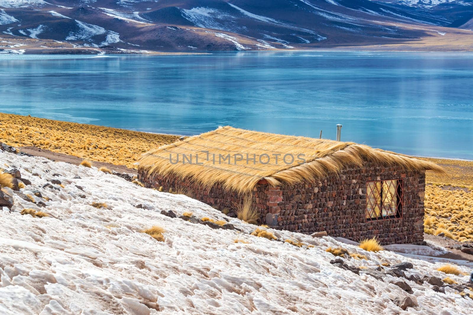 Rustic house and blue, frozen Lake Miscanti near San Pedro de Atacama in Chile