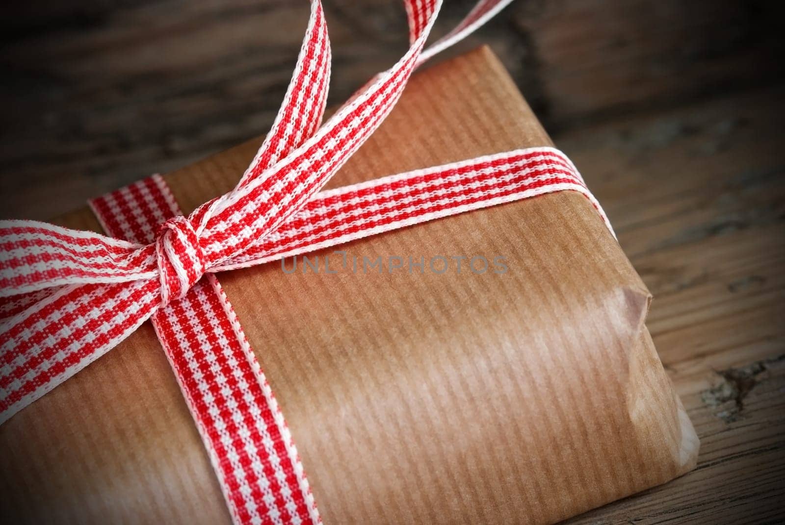 Brown Present with Red White Ribbon on Wood