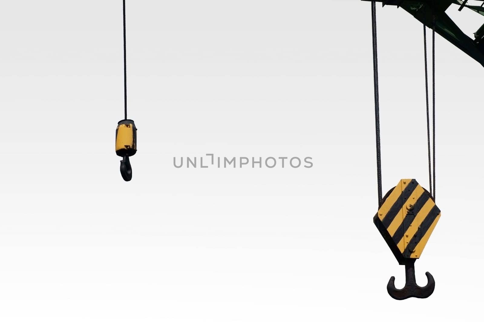 The photograph of two different winches of a lifting crane with hooks.