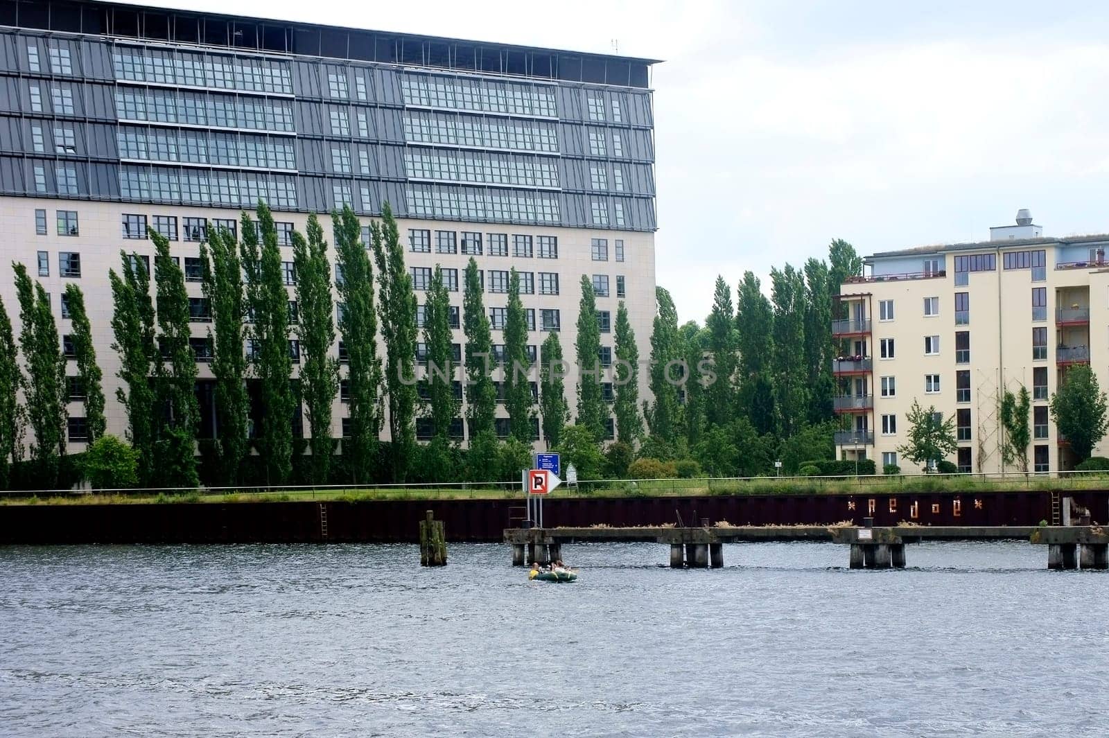The photograph of a modern residential complex with a park on a river.