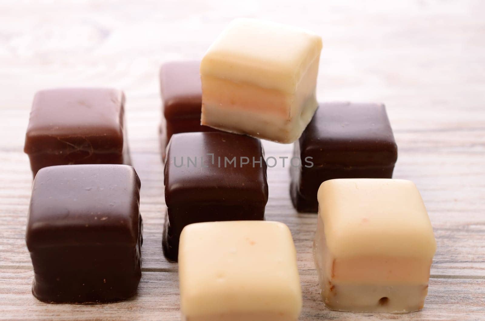 Sweet chocolate dices on a wooden table