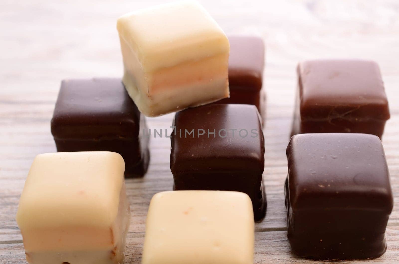 Sweet chocolate dices on a wooden table