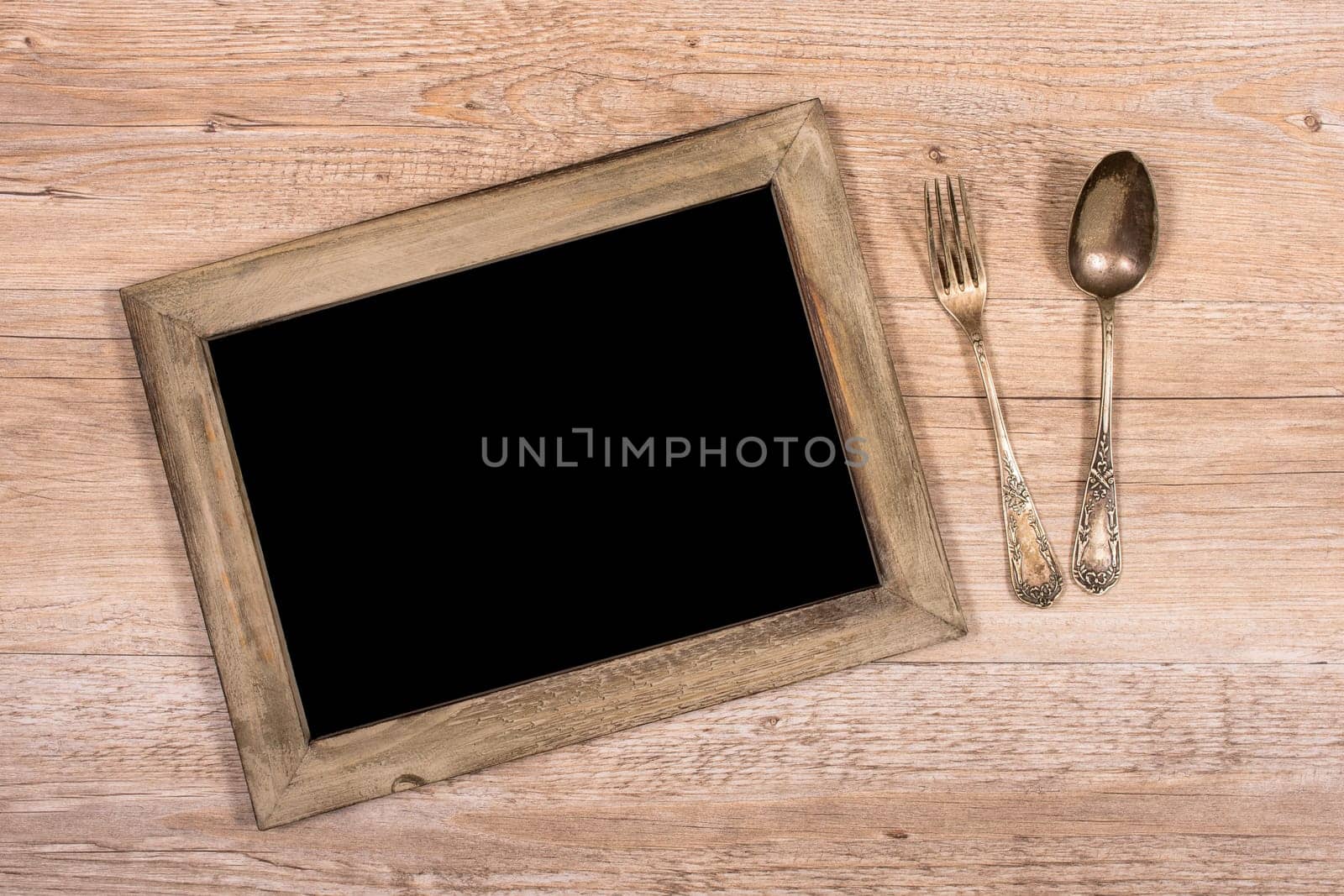 Table with frame made of wood and fork and spoon on wood