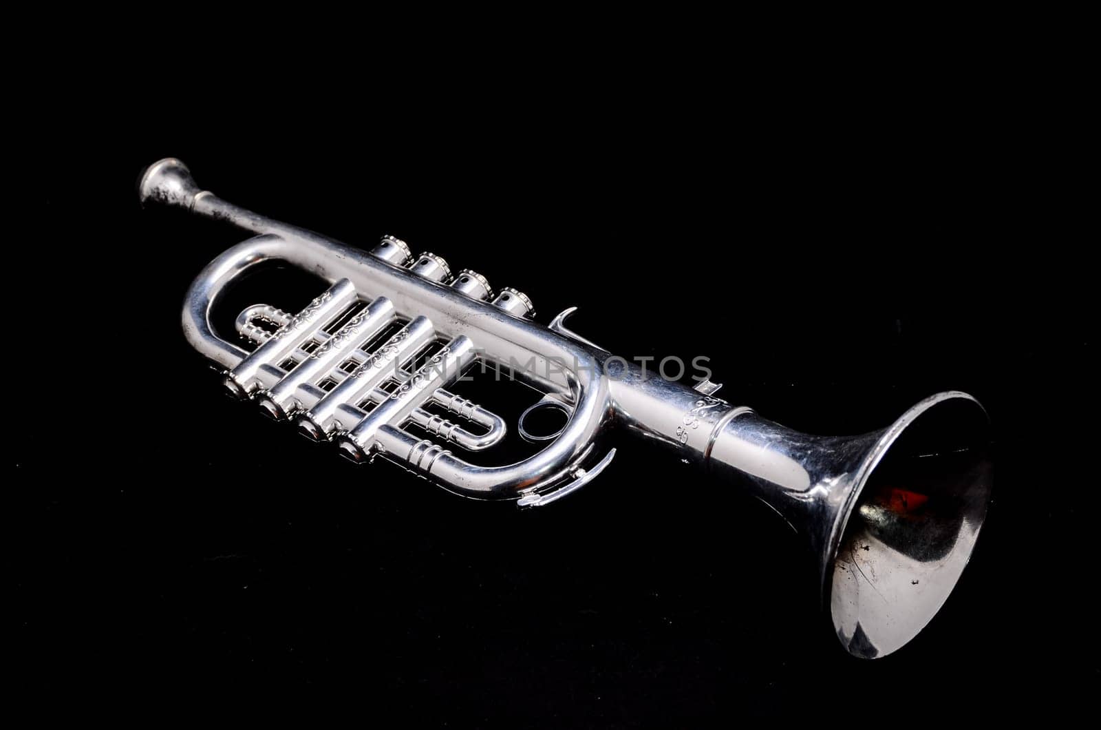 Silver Vintage Toy Trumpet on a Black Background