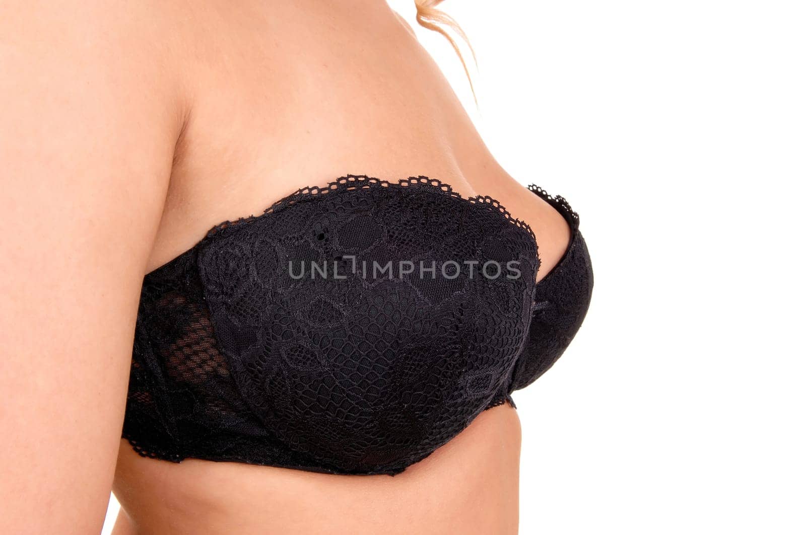 A closeup picture of the chest of a young woman wearing a black bra,.isolated on white background..