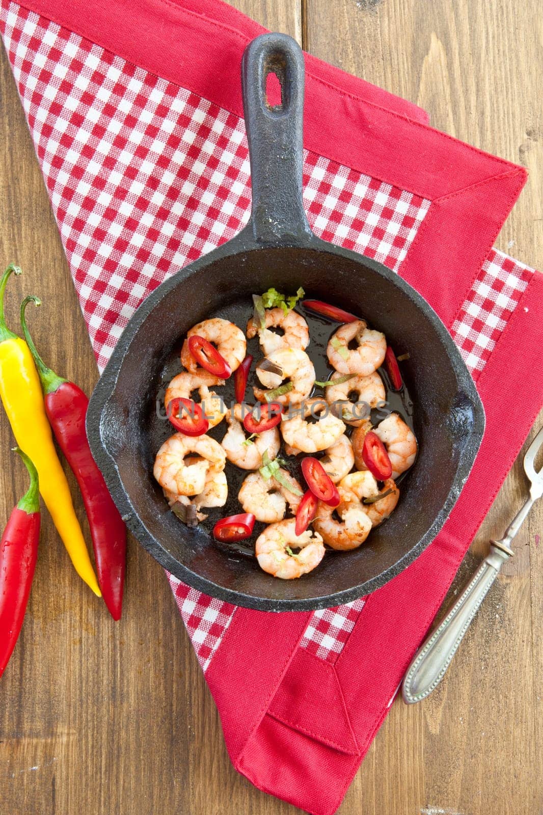 Fried shrimp with chilli in cast iron pan