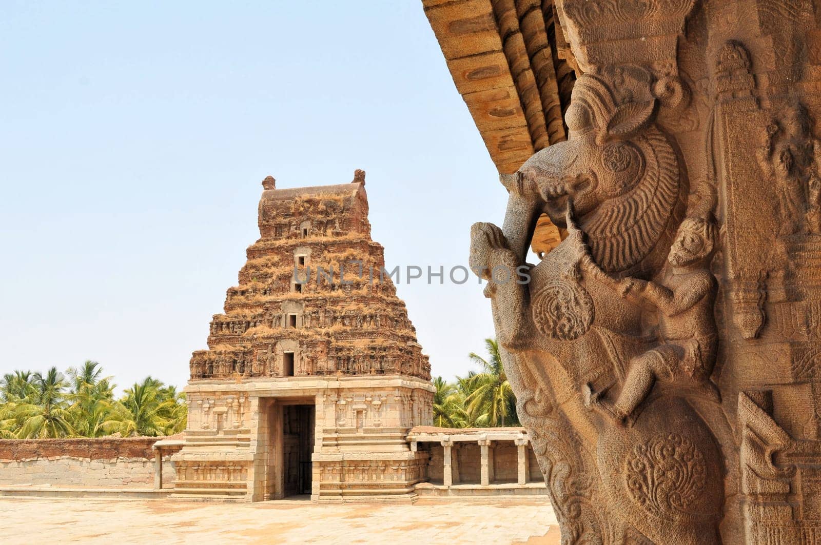 Ancient partiallyovergrown ruins of Vijayanagara Empire at sunset blue sky in Hampi, Karnataka, India