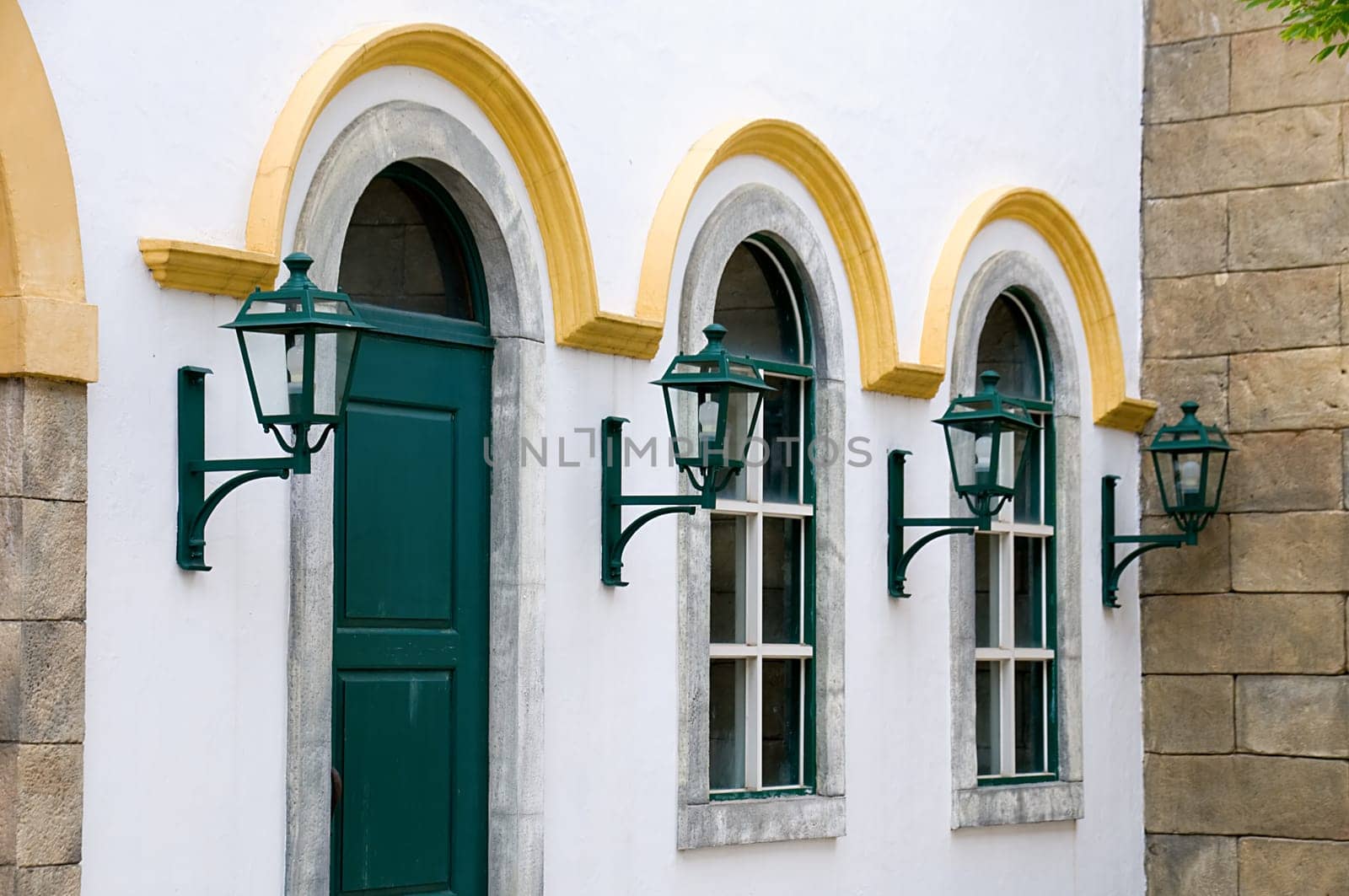 A facade shot of windows and antique lanterns